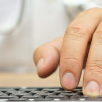 Doctor is typing diagnose on computer keyboard
